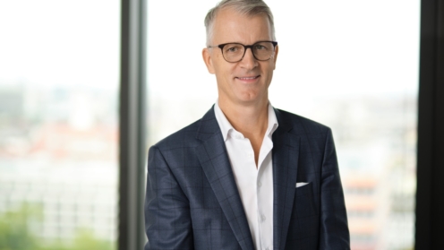 Jens Freudenberg mit einem Fenster mit Ausblick im Rücken